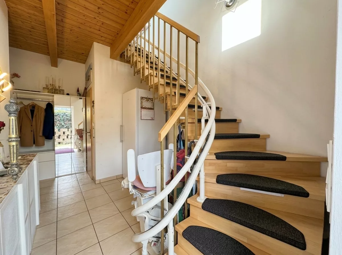 Treppe zum Obergeschoss mit installiertem Treppenlift im Einfamilienhaus in Berlin-Falkenberg.