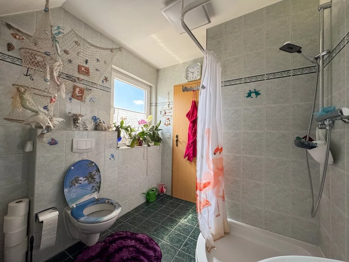 Tageslichtbad mit Dusche, WC und Fenster im Dachgeschoss des Einfamilienhauses in Berlin-Falkenberg