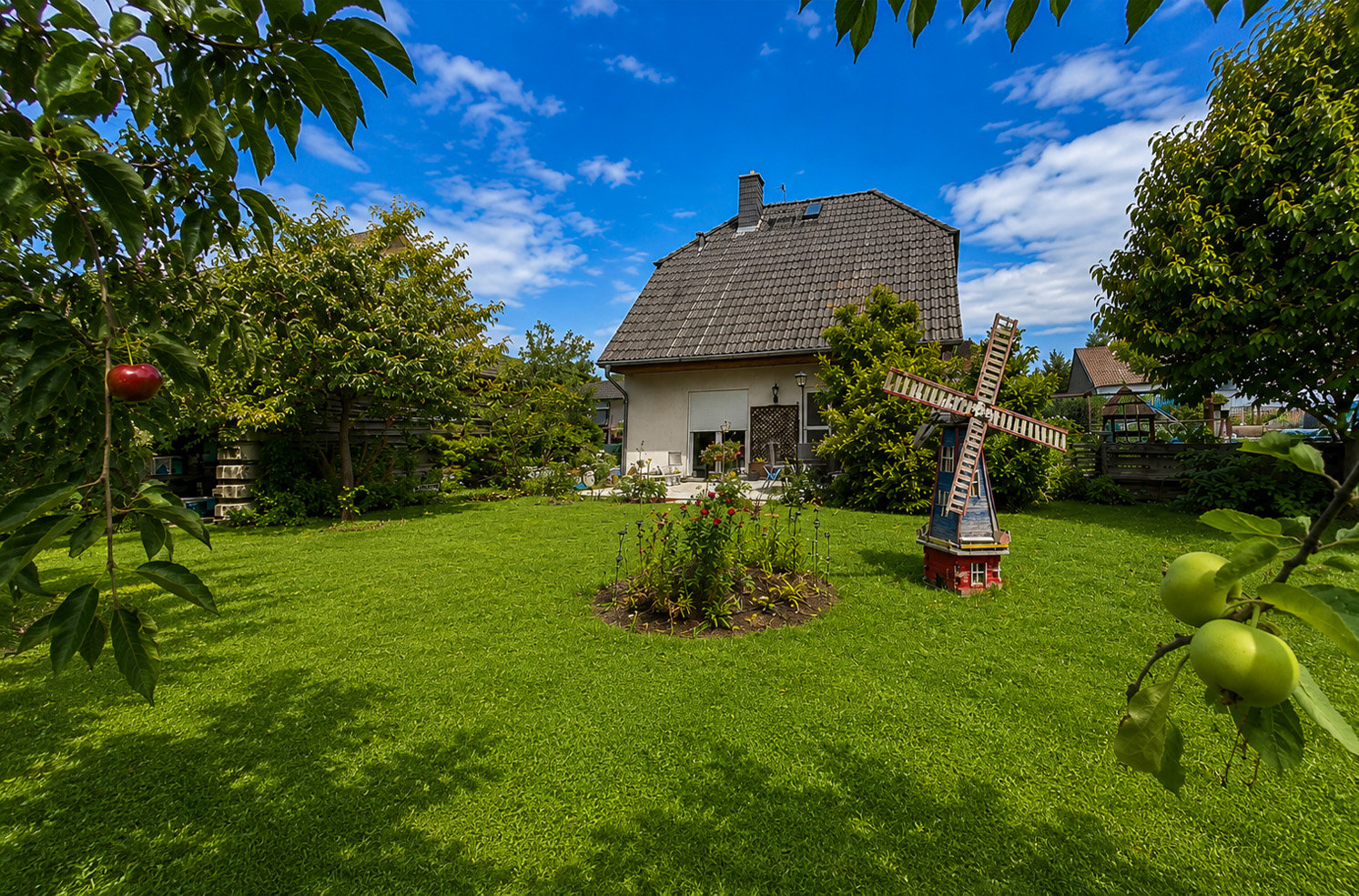 Grüner Garten mit Obstbäumen und Blick auf das Einfamilienhaus in Berlin-Falkenberg